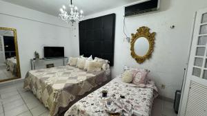 a bedroom with two beds and a mirror at Casa do Lago Salinópolis in Salinópolis +42 photos