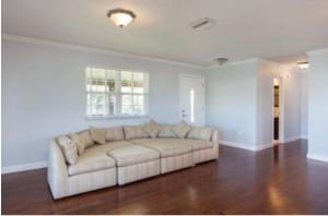 a white couch in a living room with wood floors at Peace on the River, Breathtaking Views in Cocoa