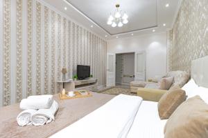 TaldykolʼにあるApartments Olimp Palace2の大きなベッドとリビングルームのある寝室