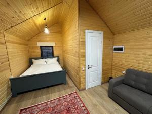 Un dormitorio con una cama y un sofá en una habitación. en Mountain View - Kolsay, en Kurmenty