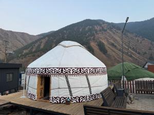 Una yurta en una terraza con montañas al fondo. en Mountain View - Kolsay, en Kurmenty