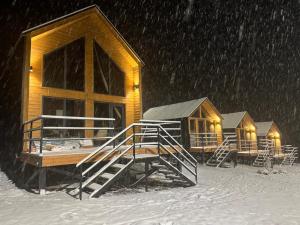 un grupo de cabañas en la nieve por la noche en Mountain View - Kolsay, en Kurmenty