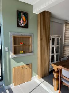 een keuken met een tafel en een houten kast bij Cambllis in Bombinhas