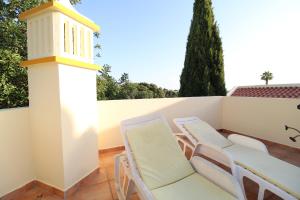 a patio with white chairs and a lighthouse at Alcaria Pool House in Altura