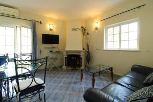 a living room with a couch and a table and a fireplace at Alcaria Pool House in Altura