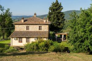 an old stone house in the middle of a yard at Stone Villa Overlooking Panicale Vineyards in Panicale