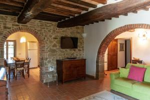 a living room with a green couch and a table at Stone Villa Overlooking Panicale Vineyards in Panicale
