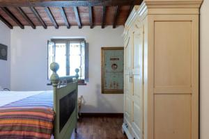 a bedroom with a bed and a closet at Stone Villa Overlooking Panicale Vineyards in Panicale +23 photos