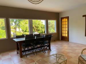 a dining room with a table and chairs and windows at Domaine Labatut in Tourrenquets