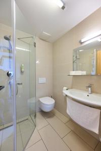 a bathroom with a toilet and a sink and a shower at Old Parish House in Bled +47 photos