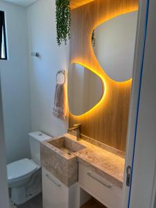 een badkamer met een wastafel en een spiegel bij Cambllis in Bombinhas +13 foto's