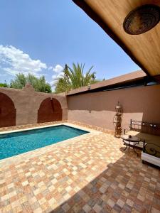 a swimming pool in front of a house at Villa des Roses Privée in Marrakech