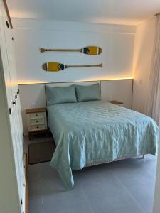 een slaapkamer met een bed met twee surfplanken aan de muur bij Cambllis in Bombinhas