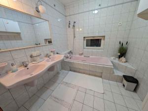 a bathroom with two sinks and a tub and a mirror at Apartment Balatonszarszo - Balaton 20085 in Balatonszárszó +24 photos