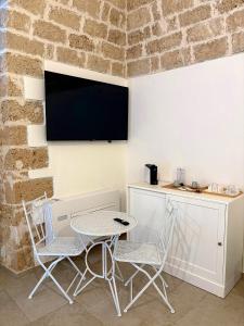 a table and two chairs and a tv on a wall at SuiteLab in Palo del Colle +23 photos