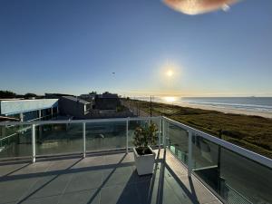 a balcony with a view of the beach at Triplex de Frente para o Mar com Piscina Privativa in Matinhos