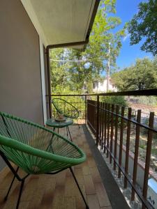 a balcony with a green chair and a table at Villa Le Querce in Badia