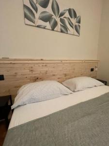 een bed met een houten hoofdeinde en een schilderij aan de muur bij Villa Le Querce in Badia