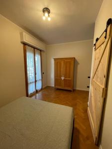 een slaapkamer met een bed en een houten vloer bij Villa Le Querce in Badia