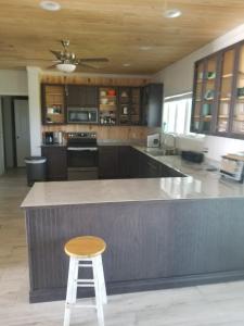 a kitchen with a bar with a stool in it at Bahamian Rhapsody of Hopetown, Elbow Cay, Abaco,BA 