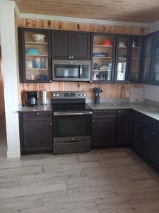 a kitchen with black cabinets and a black stove at Bahamian Rhapsody of Hopetown, Elbow Cay, Abaco,BA 