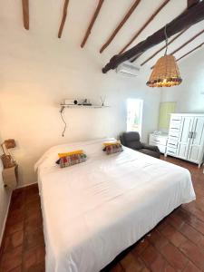 a bedroom with a large white bed in a room at Casa Castañeto Barichara in Barichara