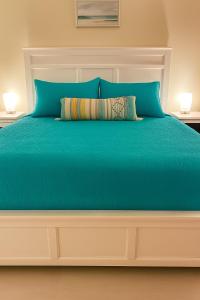 ein großes Bett mit blauer Bettdecke und zwei Lampen in der Unterkunft Sapphire Beach Resort and Marina in Nazareth