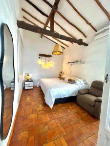 a bedroom with a bed and a couch in a room at Casa Castañeto Barichara in Barichara
