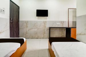 a room with two beds and a tv on the wall at Hotel O Balaji Hotel & Banquet in Boisar +24 photos
