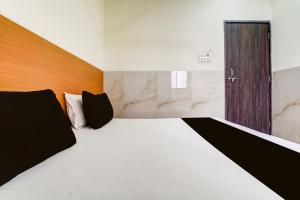 a bedroom with a large bed and a wooden door at Hotel O Balaji Hotel & Banquet in Boisar