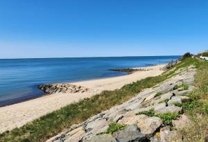 una playa con rocas y el océano en un día soleado en Seaside Escape, en Dennis 1 foto más