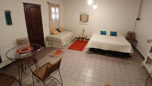 ティルカラにあるMonoambiente Tilcaraのベッド2台とテーブルと椅子のある寝室