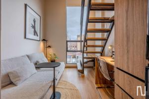 a living room with a couch and a spiral staircase at NOK Luxury Studio in Chapinero in Bogotá