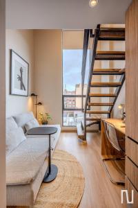 a living room with a couch and a spiral staircase at NOK Luxury Studio in Chapinero in Bogotá