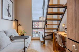 a living room with a ladder and a couch and a window at NOK Luxury Studio in Chapinero in Bogotá +8 photos