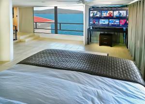 a bedroom with a bed and a flat screen tv at Villa Vista Oceanfront 4BR - Infinity Pool - Views in Enighed