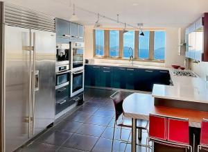 a kitchen with a stainless steel refrigerator and a table at Villa Vista Oceanfront 4BR - Infinity Pool - Views in Enighed +48 photos