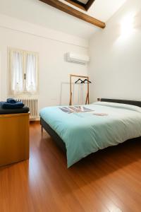 Un dormitorio con una cama grande y suelo de madera. en Casa Boara, en Ferrara