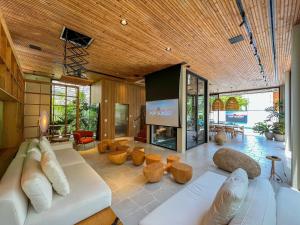 ein Wohnzimmer mit einem weißen Sofa und einem Fernseher in der Unterkunft Riviera | Luxo e Design no Golf – Cond Privativo in Riviera de São Lourenço