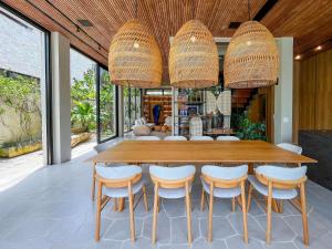 ein Esszimmer mit einem großen Holztisch und Stühlen in der Unterkunft Riviera | Luxo e Design no Golf – Cond Privativo in Riviera de São Lourenço