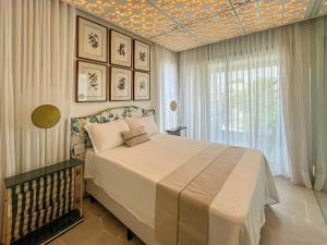 ein Schlafzimmer mit einem Bett und einer Decke mit Mustern in der Unterkunft Riviera | Luxo e Design no Golf – Cond Privativo in Riviera de São Lourenço + 92 Fotos