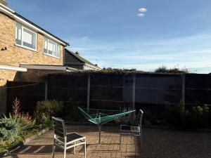 a garden with two chairs and a glass table at The Garden Studio - Private, Modern, Cozy, Ensuite in a Quiet Area in Luton