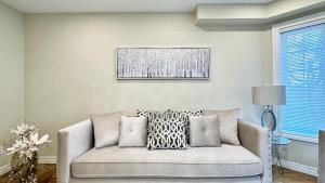 ein Wohnzimmer mit einer Couch und einem Gemälde an der Wand in der Unterkunft Designer 4BR Retreat, Luxe Living & Family-Friendly Fun in Mississauga