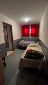 een slaapkamer met 2 bedden en rode gordijnen bij Pousada Flor de Atibaia in Atibaia