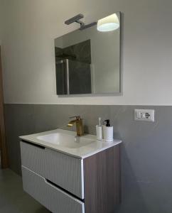 a bathroom with a sink and a mirror at Casa Vacanze Ilenia in Marina di Montemarciano