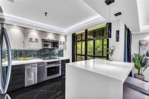 eine Küche mit einer weißen Theke und einem Waschbecken in der Unterkunft Modern Condo with Private Primary Suite in Ives Estates