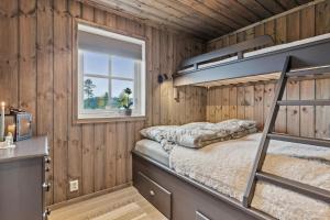 a bedroom with a bunk bed and a window at Hytte på Lygna med fantastisk utsikt in Gran