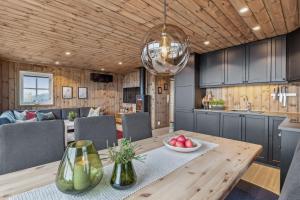 a kitchen and dining room with a wooden table at Hytte på Lygna med fantastisk utsikt in Gran