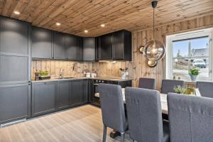a kitchen with black cabinets and a wooden ceiling at Hytte på Lygna med fantastisk utsikt in Gran +9 photos