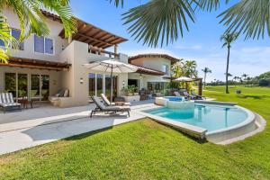 a villa with a swimming pool and a house at Residencia Palmas en Punta Mita in Puerto Vallarta